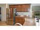 A kitchen with wooden cabinets, stainless steel appliances, and an open doorway to a bedroom at 3212 Stevenson St, Plant City, FL 33566