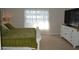 Bedroom featuring a white dresser, sheer curtains, and a comfortable bed with green bedding at 3212 Stevenson St, Plant City, FL 33566