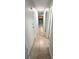 Hallway featuring a tile floor, white walls, and a view of the kitchen at 3315 58Th S Ave # 115, St Petersburg, FL 33712