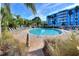 Community pool surrounded by lounge chairs and beautiful landscaping on a sunny day at 3315 58Th S Ave # 115, St Petersburg, FL 33712