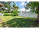 Spacious backyard with lush greenery, mature trees, and a privacy fence at 4018 E Bluff Ave, Tampa, FL 33617