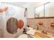 Bathroom with a patterned shower curtain, sink, toilet, decorative plants, and earth tone color scheme at 4018 E Bluff Ave, Tampa, FL 33617