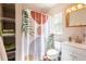 A full bathroom featuring a patterned shower curtain, white sink, and window at 4018 E Bluff Ave, Tampa, FL 33617