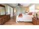 A bedroom with hardwood floors, a dresser, and a queen-sized bed with a ceiling fan above at 4018 E Bluff Ave, Tampa, FL 33617
