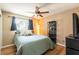 Bedroom featuring hardwood floors, a cozy bed, a window, a bookshelf, and a modern light fixture at 4018 E Bluff Ave, Tampa, FL 33617