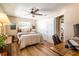 Bedroom featuring hardwood floors, a cozy bed, warm lighting, and desk with a computer at 4018 E Bluff Ave, Tampa, FL 33617