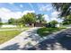 Front exterior featuring a well-manicured lawn, mature trees, and a long driveway at 4018 E Bluff Ave, Tampa, FL 33617