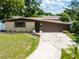 Front exterior features manicured lawn, driveway, and brick facade at 4018 E Bluff Ave, Tampa, FL 33617