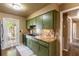 Retro kitchen with green cabinets, striking countertop and backsplash, and exterior access at 4018 E Bluff Ave, Tampa, FL 33617