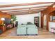 Comfortable living room with exposed beam ceiling, white brick, and hardwood floors at 4018 E Bluff Ave, Tampa, FL 33617
