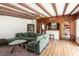 Open concept living room with beam ceiling, brick wall, wood paneling, and hardwood floors at 4018 E Bluff Ave, Tampa, FL 33617