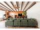 Bright living room with exposed beam ceiling, wood paneling, white brick wall, and ample seating at 4018 E Bluff Ave, Tampa, FL 33617
