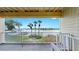 Inviting balcony view with gray deck and white railing overlooking waterfront and lush green grass with palm trees at 459 Haven Point Dr, Treasure Island, FL 33706