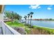 Inviting balcony view with white railing overlooking waterfront and lush green grass with palm trees and boats at 459 Haven Point Dr, Treasure Island, FL 33706