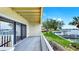 Inviting balcony view with gray deck and white railing overlooking waterfront and lush green grass and boats at 459 Haven Point Dr, Treasure Island, FL 33706