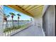 Inviting balcony view with gray deck and white railing overlooking waterfront and lush green grass with palm trees at 459 Haven Point Dr, Treasure Island, FL 33706