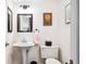 Classic powder room featuring pedestal sink, toilet, and framed wall art at 459 Haven Point Dr, Treasure Island, FL 33706