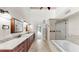 Spacious bathroom featuring a long granite-topped double vanity, walk-in shower and soaking tub at 459 Haven Point Dr, Treasure Island, FL 33706