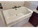 Jetted tub with tile surround complemented by a dark wood storage cabinet at 459 Haven Point Dr, Treasure Island, FL 33706