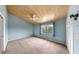 A spacious bedroom featuring blue walls, wood plank ceiling, ceiling fan, and a window for natural light at 459 Haven Point Dr, Treasure Island, FL 33706