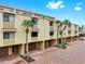 Townhouse with a brick driveway, garages, palm trees, and neutral exterior color for a bright and inviting curb appeal at 459 Haven Point Dr, Treasure Island, FL 33706