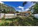 Spacious backyard with green grass, mature trees, a screened-in porch, and a white vinyl fence at 4616 5Th N Ave, St Petersburg, FL 33713