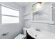 Bright bathroom features a vanity, toilet, and shower with decorative curtain, plus floating shelves at 4616 5Th N Ave, St Petersburg, FL 33713