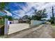 Home exterior with driveway, fenced yard, large tree, screen porch, garage, and a blue recycling bin at 4616 5Th N Ave, St Petersburg, FL 33713