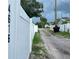 Street view showing a white vinyl fence, grassy area, and parked cars under a cloudy sky at 4616 5Th N Ave, St Petersburg, FL 33713