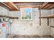 Unfinished basement interior shows concrete walls, a small window, and wooden support beams at 4816 N Fremont Ave, Tampa, FL 33603