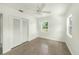 Bright bedroom featuring two windows, a ceiling fan and a closet with louvered doors at 4816 N Fremont Ave, Tampa, FL 33603