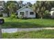 Quaint single-story home featuring a simple front facade and tropical landscaping, offering a cozy and relaxed curb appeal at 518 Woodlawn St, Clearwater, FL 33756