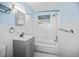 Bathroom featuring blue walls, a shower-tub combo, and updated vanity and fixtures at 551 Bay St, Dunedin, FL 34698