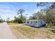 Charming home featuring a light blue exterior, well-maintained lawn, and a driveway at 551 Bay St, Dunedin, FL 34698