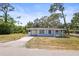 Charming single-story home featuring a light blue exterior, well-maintained lawn, and a driveway at 551 Bay St, Dunedin, FL 34698