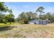 Charming single-story home with a large front yard, mature trees, and a light blue exterior at 551 Bay St, Dunedin, FL 34698