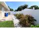 Spacious backyard with a white fence, vibrant greenery, and meticulously arranged landscaping along the perimeter at 6045 2Nd N Ave, St Petersburg, FL 33710