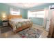 Bright bedroom with a light wood frame bed, a floral comforter, and matching floral rug at 6045 2Nd N Ave, St Petersburg, FL 33710