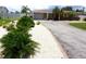 Charming single-story home featuring a circular driveway and landscaped front yard with lush greenery and palm trees at 6045 2Nd N Ave, St Petersburg, FL 33710