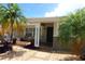 Inviting covered front porch with tiled flooring, seating, and mature palm trees at 6045 2Nd N Ave, St Petersburg, FL 33710