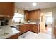 Sunlit kitchen featuring wood cabinets, stone countertops, stainless steel appliances, and views to the adjacent room at 6045 2Nd N Ave, St Petersburg, FL 33710