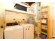 Practical laundry room equipped with a washing machine, dryer, and storage shelving for household supplies at 6045 2Nd N Ave, St Petersburg, FL 33710