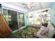 Relaxing sunroom with hanging chair, comfortable seating, and view of the landscaped backyard at 6045 2Nd N Ave, St Petersburg, FL 33710