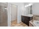 A well-lit bathroom with a dark wood vanity, white countertop, walk-in shower, and separate toilet room at 6519 Watson Rd, Riverview, FL 33578