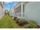 Rear exterior view showcasing a screened-in patio and white railings with manicured landscaping at 6519 Watson Rd, Riverview, FL 33578