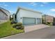 Exterior featuring a two-car garage, well-maintained landscaping, and a light blue painted facade at 6519 Watson Rd, Riverview, FL 33578
