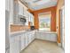 Bright kitchen features white cabinetry, stainless steel microwave, and a window overlooking the backyard at 6519 Watson Rd, Riverview, FL 33578