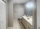 Bathroom featuring dual sinks, tile flooring, and ample cabinet storage at 7148 E Bank Dr # 7148, Tampa, FL 33617