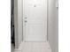 A white front door sits in front of an entryway with tile flooring at 7148 E Bank Dr # 7148, Tampa, FL 33617