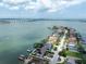 Waterfront home with a boat dock, solar panels, lush landscaping, and beautiful patio at 8 Sunset Bay Dr, Belleair, FL 33756